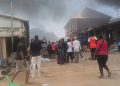 Traders stand near the scene of a fire outbreak at Kugbo Furniture Market in Abuja.