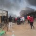 Traders stand near the scene of a fire outbreak at Kugbo Furniture Market in Abuja.