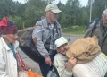 Four residents carrying personal belongings as they leave Oleshky in southern Ukraine.(photo credit Ksenia Arkhipova BBC)