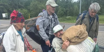 Four residents carrying personal belongings as they leave Oleshky in southern Ukraine.(photo credit Ksenia Arkhipova BBC)
