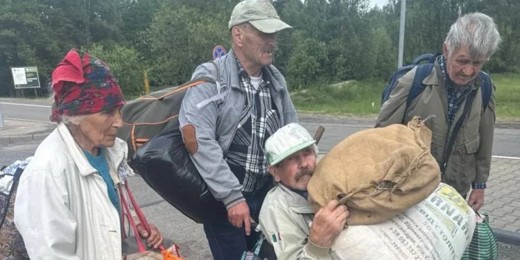 Four residents carrying personal belongings as they leave Oleshky in southern Ukraine.(photo credit Ksenia Arkhipova BBC)